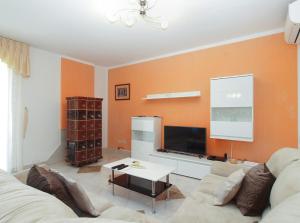 uma sala de estar com um sofá e uma televisão em House Marija 2036 em Rabac