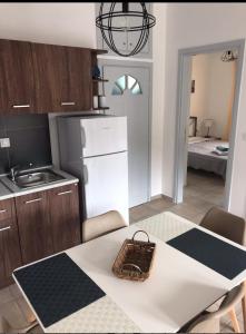 a kitchen with a white refrigerator and a table at Colorful house in Kriopigi in Kriopigi