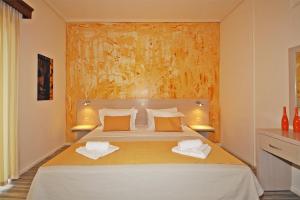 a bedroom with a bed with two towels on it at Akti Kalogria Hotel in Kalogria