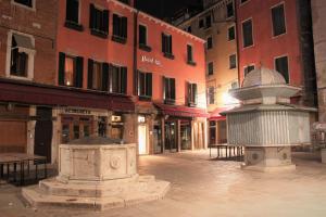 a stone fountain in the middle of a city street at Hotel Rio in Venice