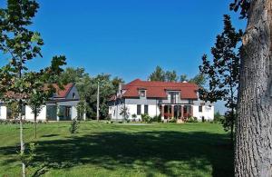 a large white house with a red roof at Penzion Platan in Ňárad