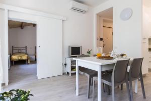 a white dining room with a white table and chairs at La casa del tenore in Recanati