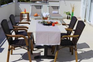 einen Tisch und Stühle auf einer Terrasse mit Essen drauf in der Unterkunft App Sanny with nice terrace in Malinska + 8 Fotos