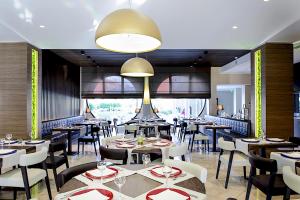a restaurant with tables and chairs and a large window at Enjoy Garda Hotel in Peschiera del Garda