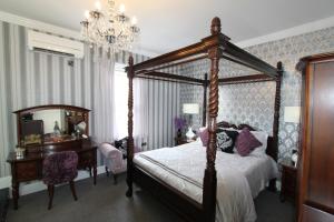 um quarto com uma cama de dossel e uma mesa e cadeira em Tower Guest House em York