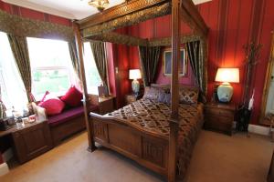 1 dormitorio con cama con dosel y paredes rojas en Tower Guest House, en York