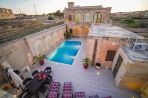 Cette chambre offre une vue sur une maison dotée d'une piscine. dans l'établissement Sant Anton tal-Qabbieza Farmhouse, à Kerċem