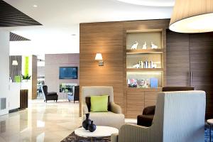a lobby with two chairs and a green pillow at Enjoy Garda Hotel in Peschiera del Garda