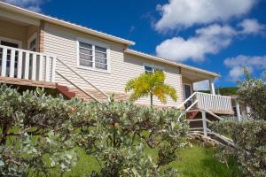 a house with a porch and stairs in front of it at South Coast Horizon in Curtain Bluff