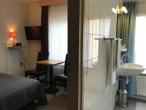 a hotel room with a bed and a desk at Hotel Heynen in Valkenburg