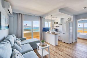 salon z niebieską kanapą i kuchnią w obiekcie Sur suites stella maris w mieście Fuengirola