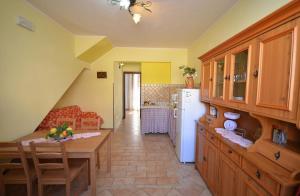 una cocina con mesa y una cocina con refrigerador en Casa Sarina, en San Vito lo Capo
