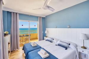 sypialnia z łóżkiem i widokiem na ocean w obiekcie Sur suites stella maris w mieście Fuengirola