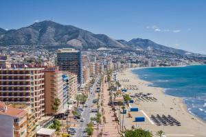 widok na plażę z budynkami i ocean w obiekcie Sur suites stella maris w mieście Fuengirola
