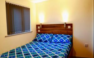 a bedroom with a bed with blue sheets and a window at The Liverpool Pod Travel Hostel in Liverpool