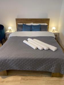 a bed with two white towels on top of it at Take PRO Timisoara Apartment in Timişoara