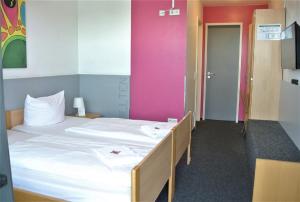 a bedroom with a large white bed with a pink wall at Chillten Bottrop in Bottrop +19 photos