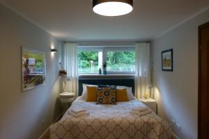 a bedroom with a bed with yellow pillows and a window at Apartamenty BB nad Kryniczanką in Krynica Zdrój