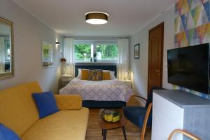 a small living room with a bed and a tv at Apartamenty BB nad Kryniczanką in Krynica Zdrój