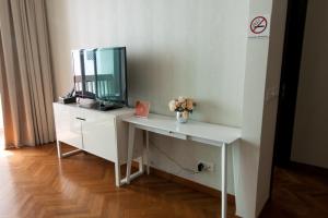 a white dressing table with a mirror and a vase of flowers at Profolio @ Straits Quay in George Town