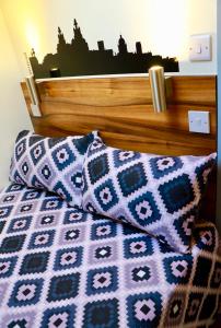 a bed with two pillows and a head board at The Liverpool Pod Travel Hostel in Liverpool