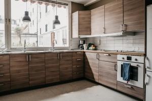 una cocina con armarios de madera y una gran ventana en På Hörnet Vandrarhem & Hotell, en Karlskrona