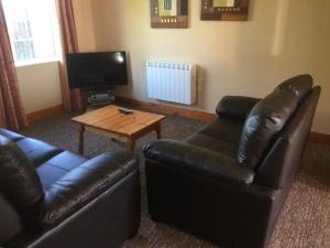a living room with two leather couches and a coffee table at Killarney Country Club in Faha