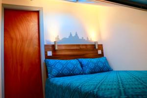 a bedroom with a bed with a wooden head board at The Liverpool Pod Travel Hostel in Liverpool