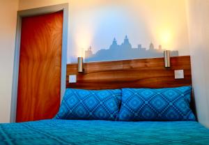 a bedroom with a bed with a wooden head board at The Liverpool Pod Travel Hostel in Liverpool