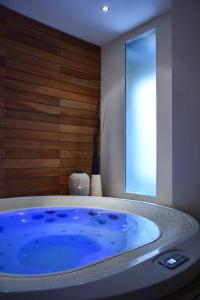Hotel Touring Wellness & Beauty في فيوجي: حوض أزرق كبير في غرفة مع نافذة