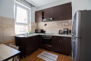 a kitchen with brown cabinets and a stainless steel refrigerator at sweet house in Arad