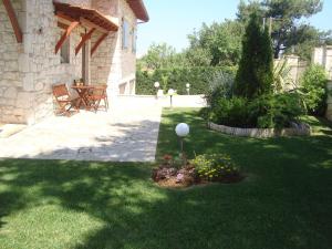 a garden with a table and flowers in a yard at Villa Traditional Estate Heated Pool & Garden, 5 bedrooms in Metókhion Patriotikón