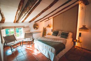 a bedroom with a bed and two chairs in it at VILASIRA ( Rooms & Wines ) in Los Cojos