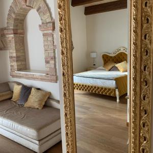 een spiegel in een slaapkamer met een bed en een bank bij Agriturismo De Luca in Mozzagrogna
