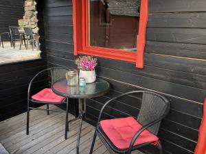 una mesa y sillas en un porche con espejo en Haugo utleige lodge, en Vossevangen