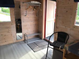 Cette chambre en bois dispose d'une chaise et d'une fenêtre. dans l'établissement Haugo utleige lodge, à Vossevangen