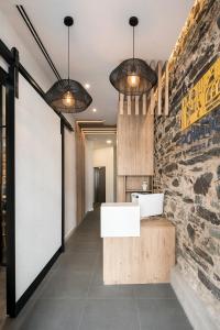 baño con 2 luces colgantes y pared de piedra en Hostal Pórtico, en Betanzos