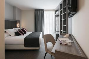 a hotel room with a bed and a table at Hostal Pórtico in Betanzos