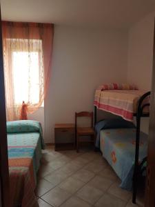 een slaapkamer met 2 stapelbedden en een stoel bij Casa da Tonia Peschici in Peschici