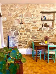 d'une salle à manger avec une table et un mur en pierre. dans l'établissement Assisi Anfiteatro Romano, à Assise