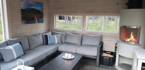 a living room with a couch and a fireplace at Pyhäkirnu Cottage in Pyhätunturi