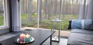 uma sala de estar com uma mesa e velas e uma janela em Pyhäkirnu Cottage em Pyhätunturi