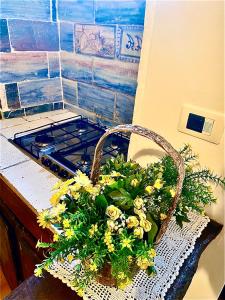 un panier rempli de fleurs jaunes sur un comptoir dans l'établissement Assisi Anfiteatro Romano, à Assise