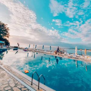 - une piscine avec des chaises et de l'eau dans l'établissement Renissa's Beach Suite, à Vlorë