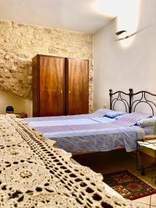 - une chambre avec un lit et une armoire en bois dans l'établissement Assisi Anfiteatro Romano, à Assise