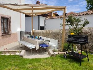 een patio met een tafel en een piano in de tuin bij Casa Dolfín - "Tu hogar en la costa del paraíso" in Naves