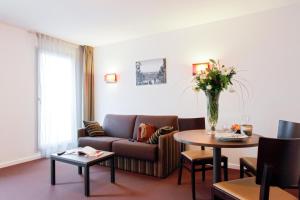 a living room with a couch and a table at Aparthotel Adagio Access Marseille Saint Charles in Marseille