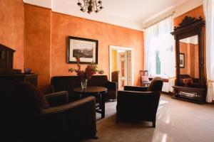 a living room with orange walls and a table and chairs at Dwór Podstolice - House of Rosenthal in Podstolice