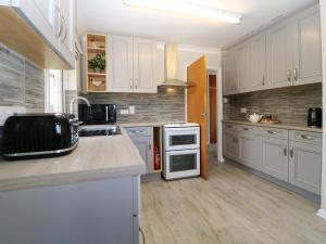 a kitchen with white cabinets and a counter top at Hedgerow in Totnes