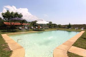 a swimming pool with a fountain in a yard at Hotel Llano Tineo in Villanueva de la Vera